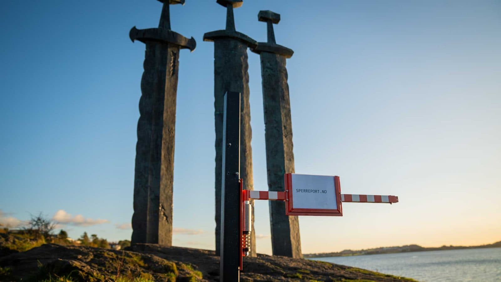 Sperreport i lukket posisjon foran Sverd i fjell-monumentet, med Hafrsfjord og blå himmel bak