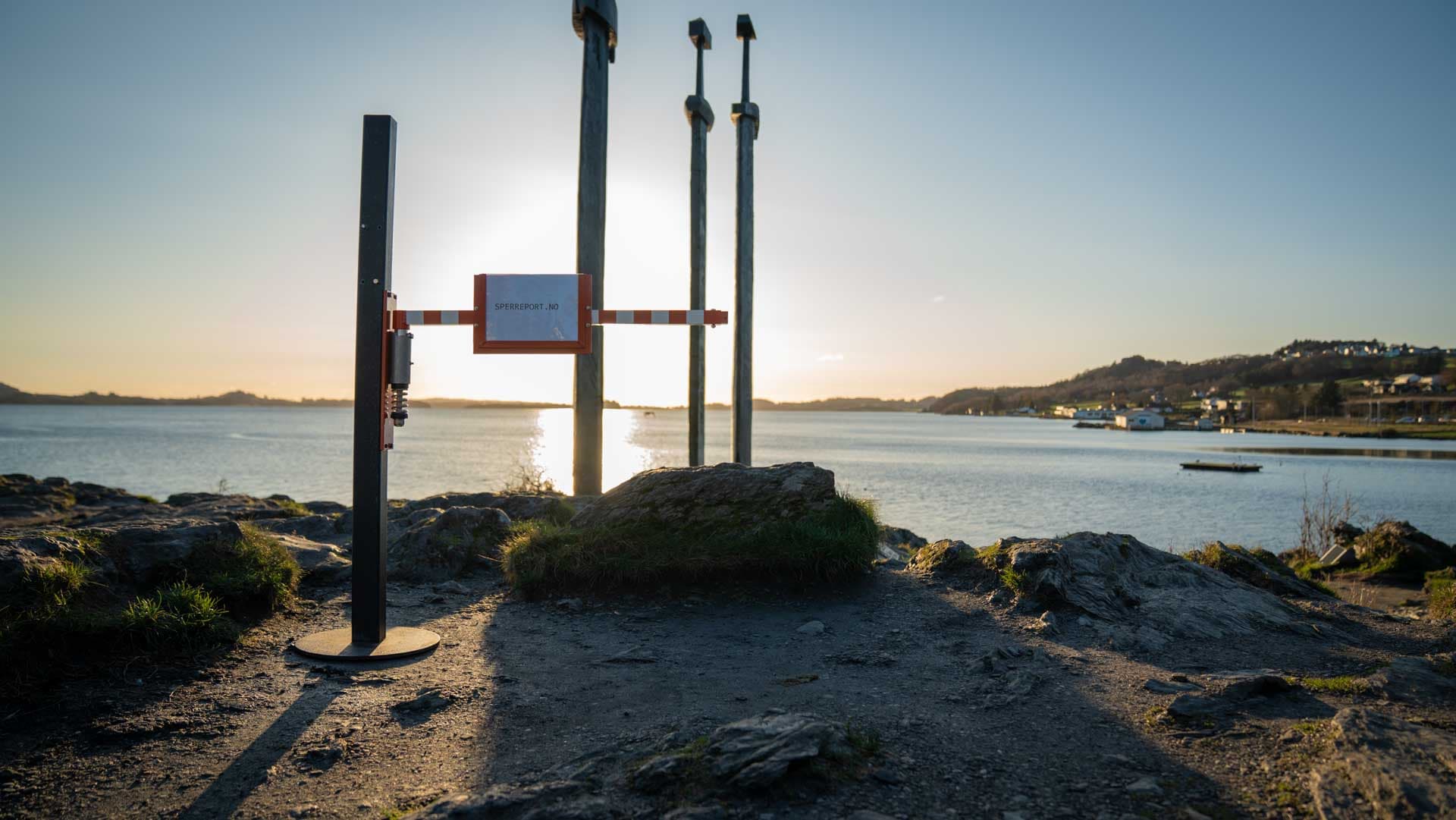 Sperreport montert på svart stolpe med utsikt over fjorden og Sverd i fjell i solnedgang